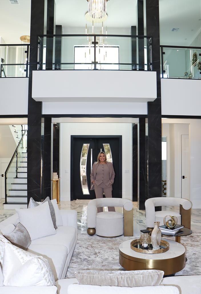 Luxury double-height living room in Lady Lake, Florida, featuring bold black-and-white architecture, warm gold accents, custom furnishings, and modern residential interior design.
