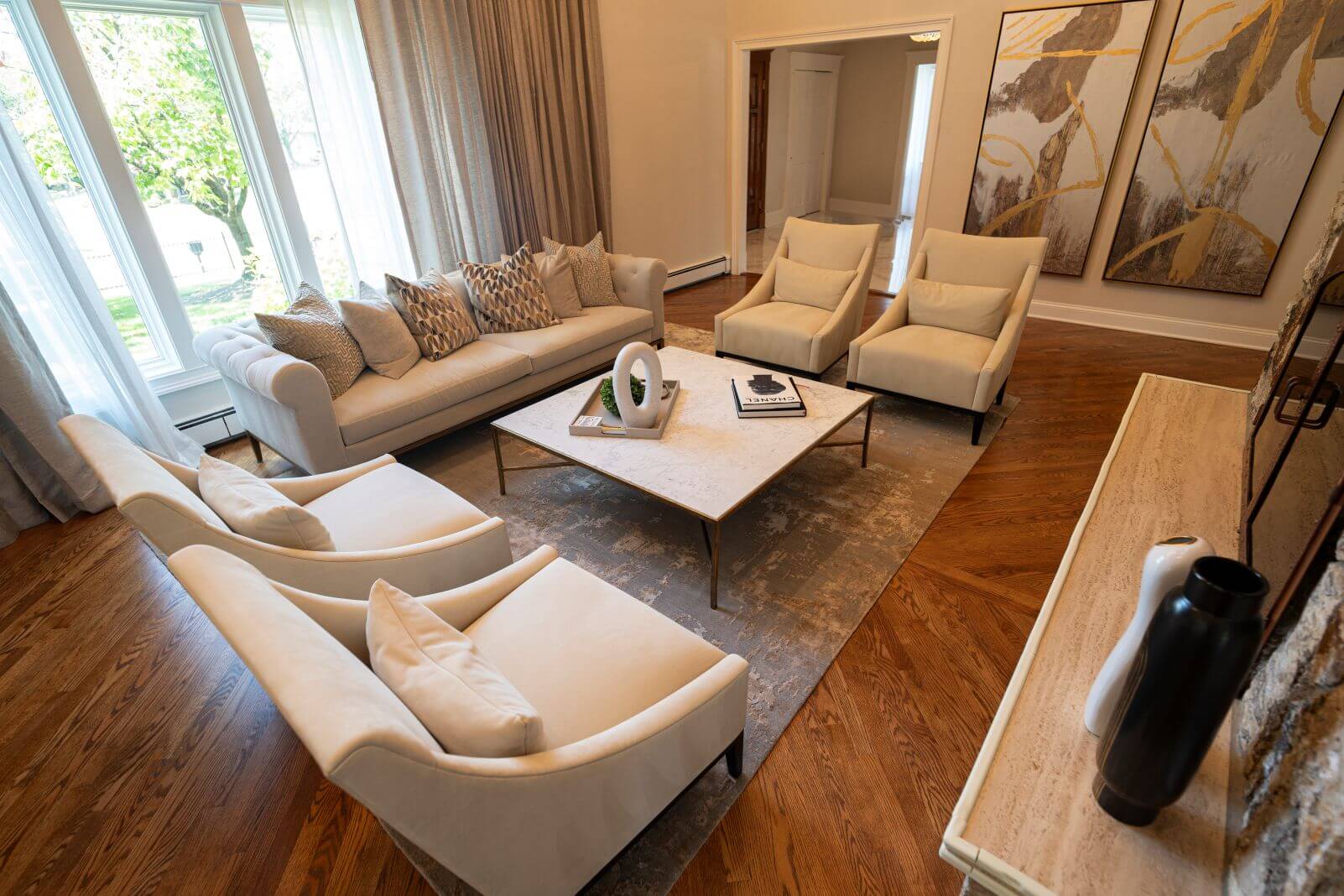 Overhead view of a professionally furnished living room featuring custom seating arranged around a marble coffee table and dramatic stone fireplace.