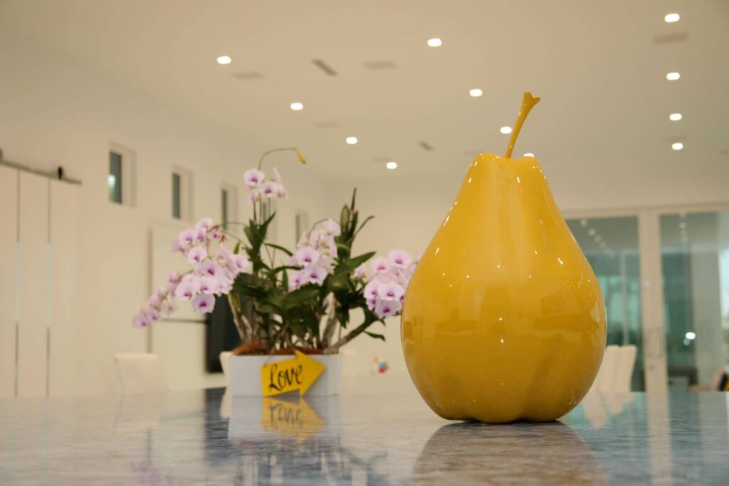Decorative accessories and fresh orchids styled on the kitchen island inside Canvas Sur luxury residence in Windermere, Florida.