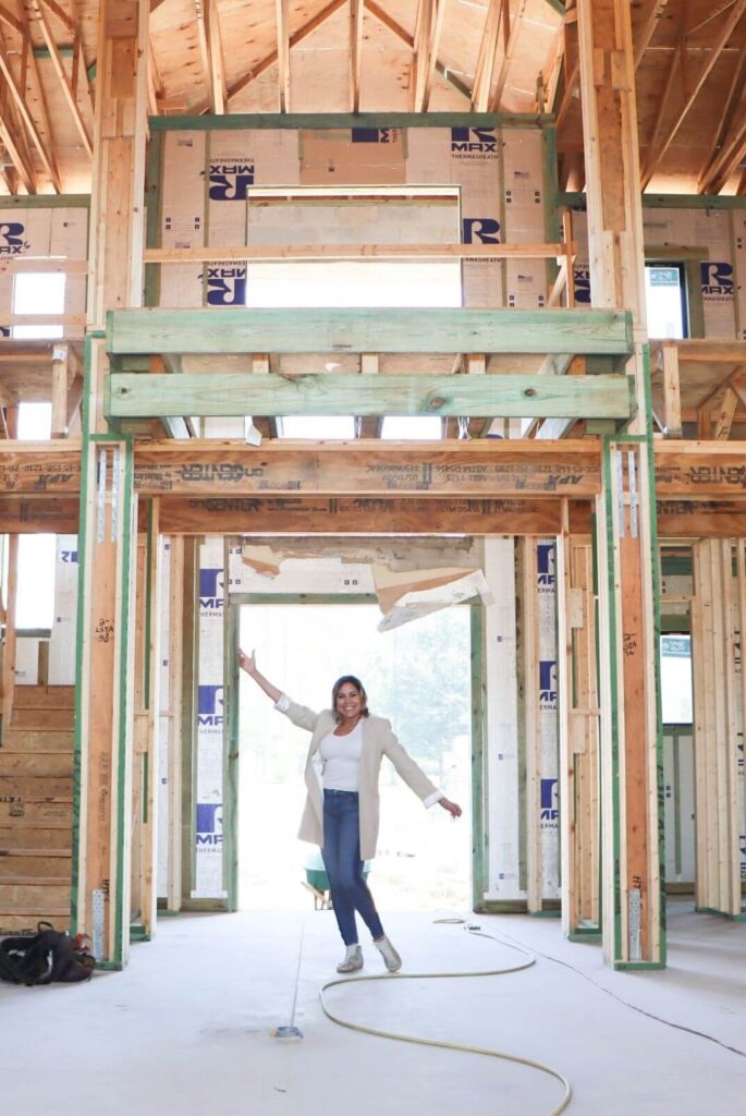 Framed double-height great room under construction in Flaava House in Lady Lake Florida, showcasing soaring ceilings and expansive architectural volume.